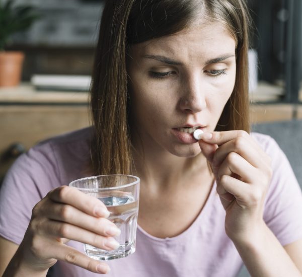 close-up-sick-young-woman-taking-medicine
