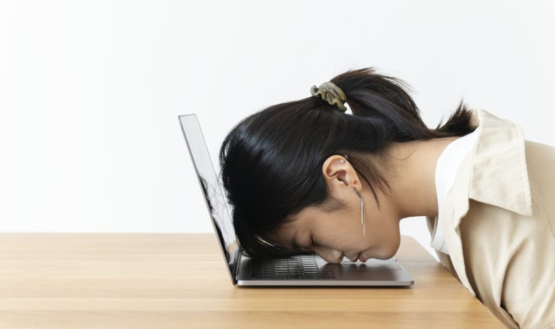 Stressed Asian girl resting her head on a laptop Stressed Asian girl resting her head on a laptop
